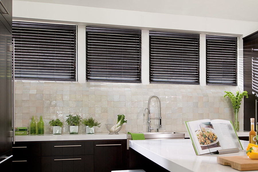 Choose custom Polywood faux wood blinds for your kitchen in Charlotte. Special shaped faux wood blinds in several windows above a sink.