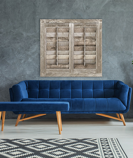 living room with reclaimed wood shutters and a modern blue couch