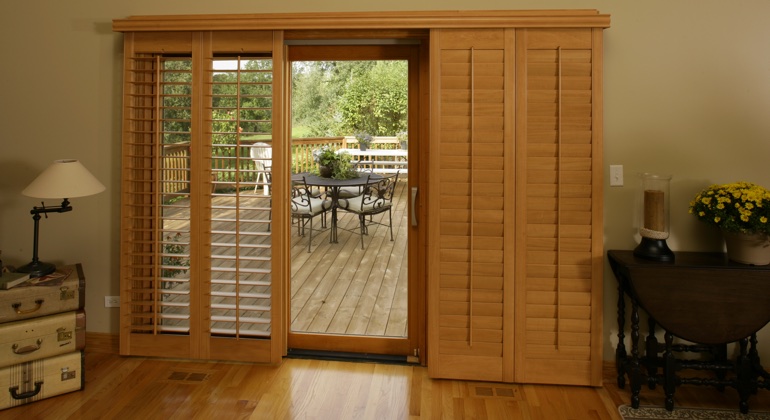 Wood shutters create a buffer that transitions from indoor wood to patio. Charlotte wood shutter sliding door